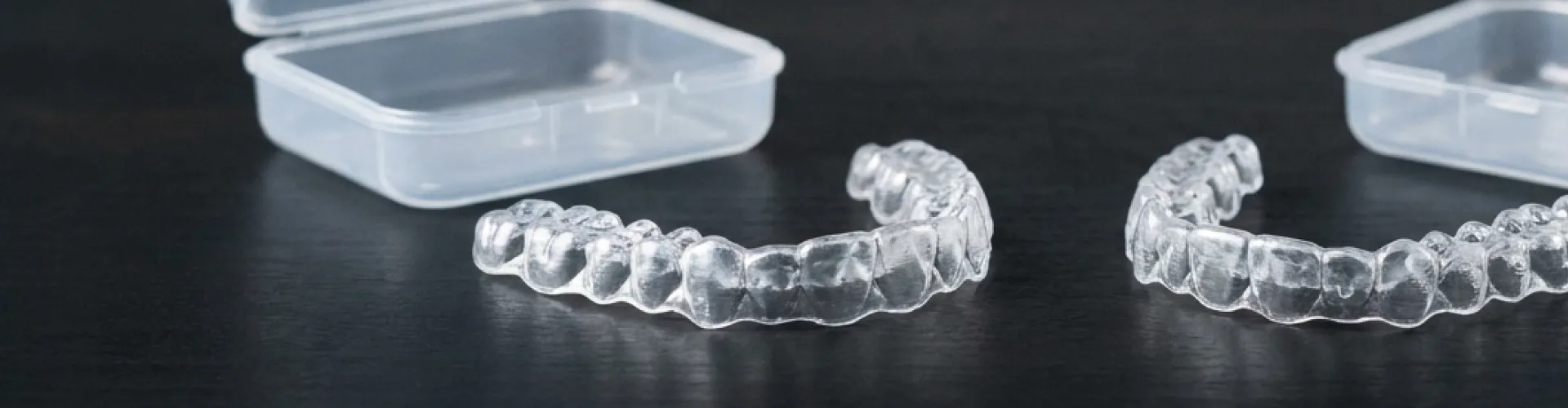 Pair of clear aligners with cases.