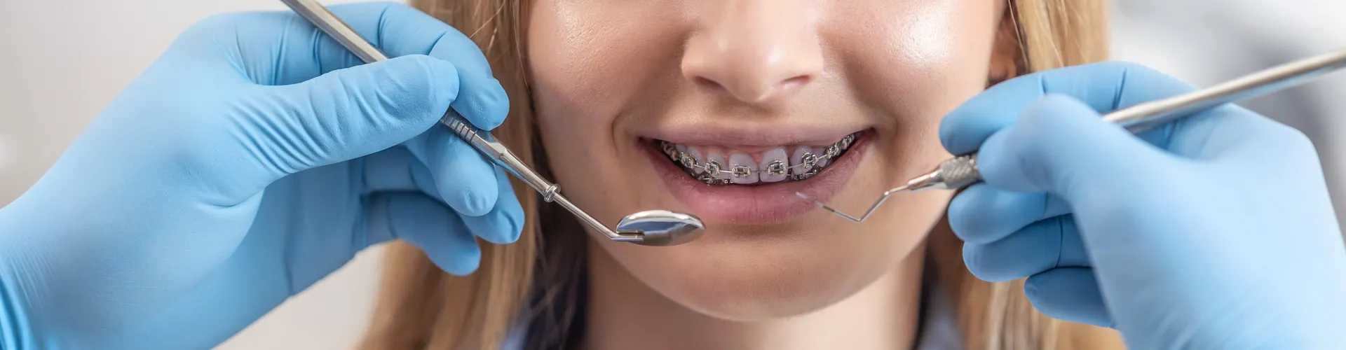 Smiling young woman wearing clear aligners to straighten her teeth.