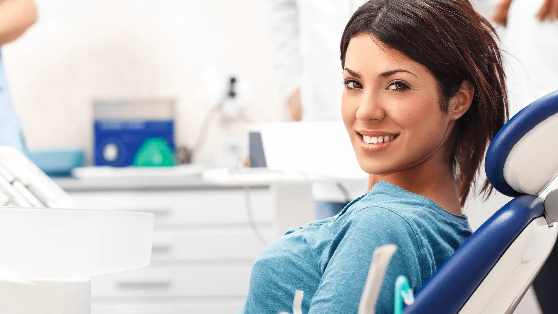 An image of a woman smiling in a dental chair