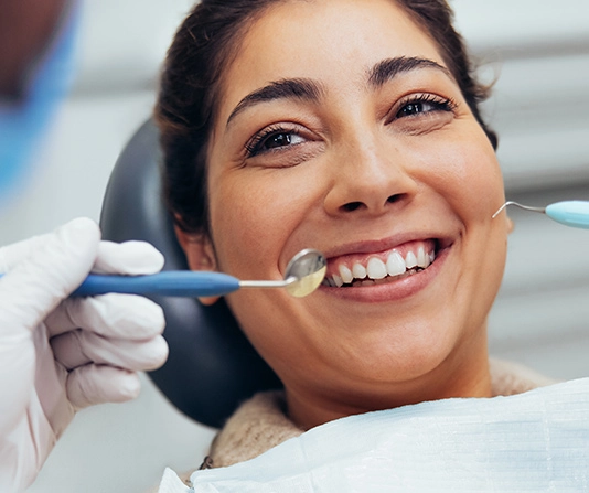 Smiling woman in dental chair having oral examination
